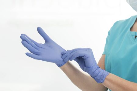 Midsection of surgeon wearing gloves against white backgroundの写真素材