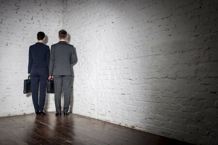 Full length rear view of business colleagues standing in corner at officeの写真素材