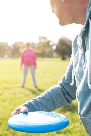 Cropped image of senior man playing with flying disc on sunny dayの写真素材