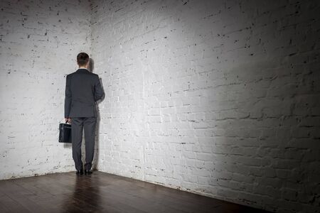 Full length rear view of businessman standing in corner at officeの写真素材