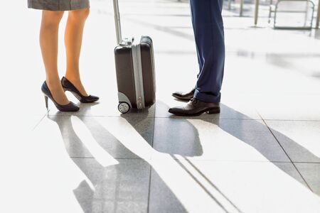 Cropped image of businessman and businesswoman standing in airportの写真素材
