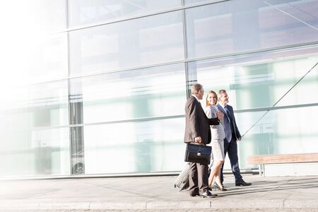Business people walking while talking in airportの写真素材