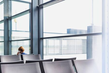 Photo of empty chairs on airport gate with lens flareの写真素材