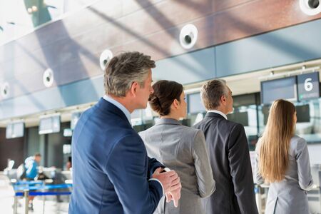 Business people queueing for check in at airportの写真素材