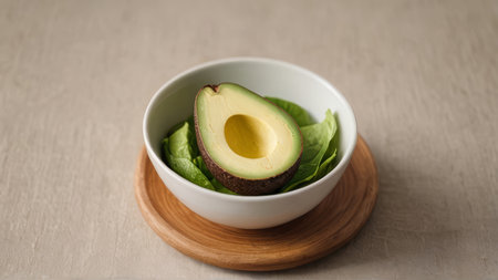 Avocado and lettuce salad in a bowl on a wooden background.
