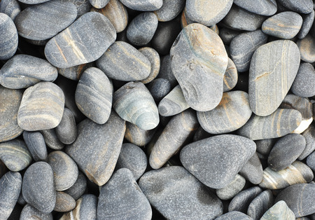Colorful pebbles touching wave at beautiful rock island, called Koh Hin Ngam, near Lipe island, Thailandの写真素材