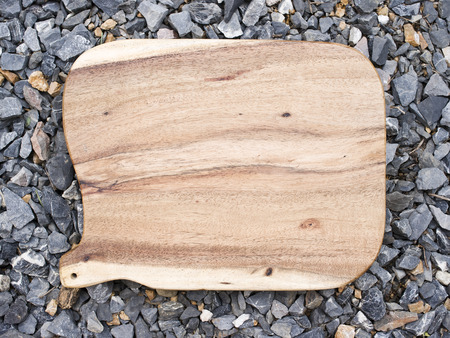 Wooden trencher chopping block on pebble.の写真素材