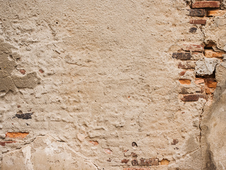 Old brick wall with cracked stucco layer.の写真素材