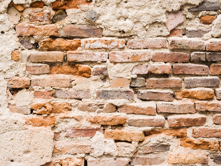 Old brick wall with cracked stucco layer.の写真素材