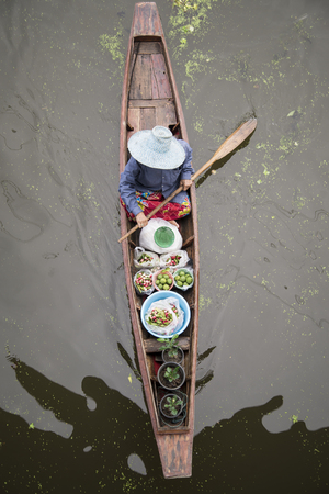 RATCHABURI THAILAND -Oct 3: Wooden boats are loaded with fruits from the orchards at Tha kha floating market on October 3, 2015 in Ratchaburi,Thailand. A traditional way still practiced in Tha kha canals of Thailand.のeditorial素材
