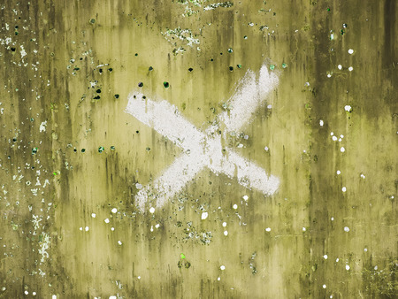 Old damaged metal surface with x letter.の写真素材