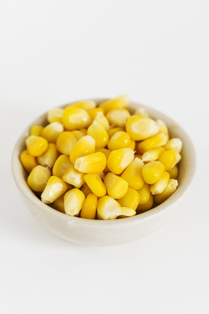 Grains of Corn in a dish on White Background.の写真素材