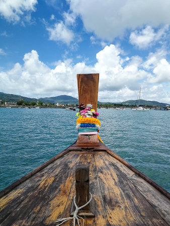 Thai wooden head longtail boat heads toward Chalong Pier in Phuket, Thailand (Selective Focus)の写真素材