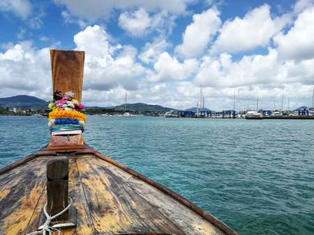 Thai wooden head longtail boat heads toward Chalong Pier in Phuket, Thailand (Selective Focus)の写真素材