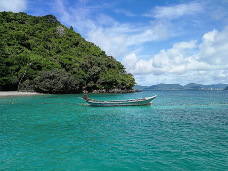 An old wooden motor boat tied to the seashore of the Banana beach of the Hay island in Phuket, Thailandの写真素材