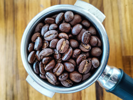 Roasted coffee beans in portafilter holder. Close upの写真素材