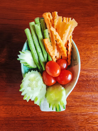 A bowl of fresh cucumbers, tomatos, string beans and carrots as a side dish (Selective Focus)の写真素材