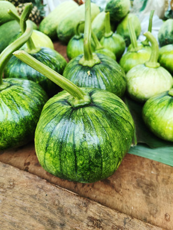 Close up of green young pumpkin fruits on  wood background. (Selective Focus)の写真素材