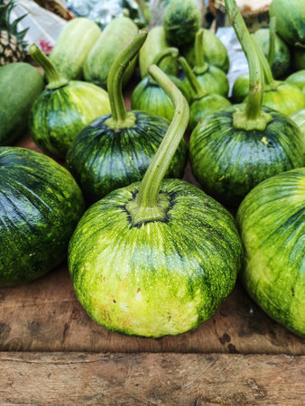 Close up of green young pumpkin fruits on  wood background. (Selective Focus)の写真素材