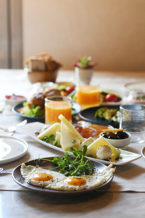 Delicious food served on various plates on a tableの写真素材