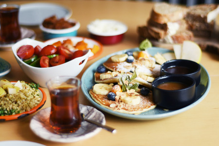 Delicious breakfast with pancakes and tea on a tableの写真素材
