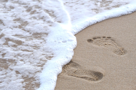Footprints in the sand leading to the seaの写真素材