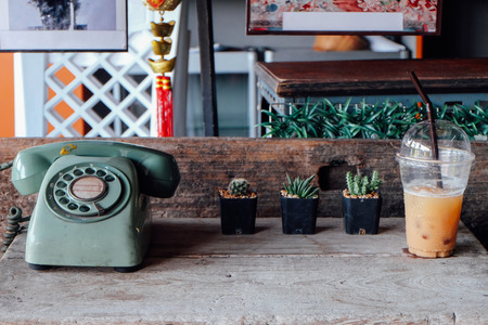 vintage telephone on wooden table with plants , coffeeの写真素材