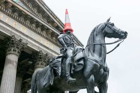 Statue of Duke of Wellington, riding a horse, wearing a traffic cone on his head. In front of Gallery of Modern Art, Royal Exchange Square, Glasgow, Scotland.のeditorial素材