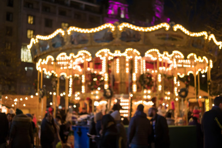 Blurred image bokeh of People walking around carousel in Edinburgh Christmas Market. New Year.の写真素材