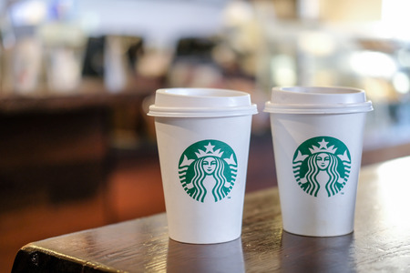 Edinburgh, United Kingdom - 14 Febuary 2017 : Starbucks take away, hot beverage coffee cup with logo, on the table in store. Starbucks is one of the most world famous coffeehouse chain from USAのeditorial素材