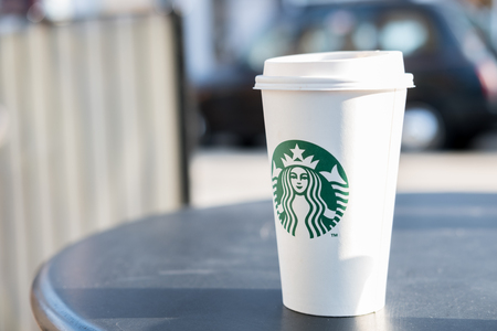 Edinburgh, United Kingdom - 14 Febuary 2017 : Starbucks take away, hot beverage coffee cup with logo, on the table in store. Starbucks is one of the most world famous coffeehouse chain from USAのeditorial素材
