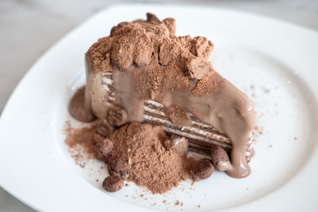 Chocolate crepe cake on white plate