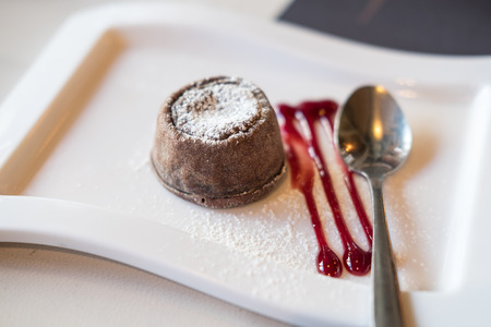 Chocolate lava on plate, with sauce and spoonの写真素材