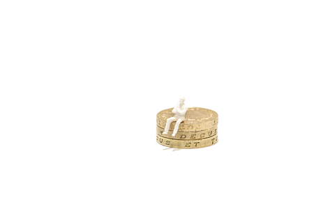 Miniature man sitting on top of British Pound Coin stack. On white background with space for text....