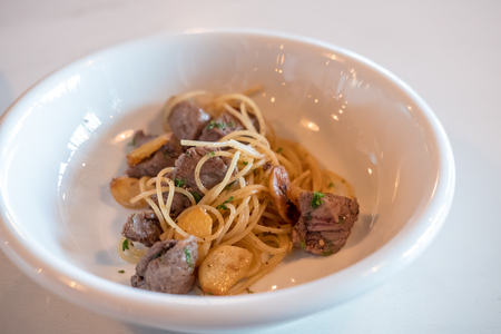 Spicy wagyu meat spaghetti served on white plateの写真素材