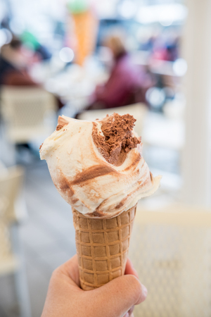 Hand holding Chocolate Gelato, Ice-cream with blur background.の写真素材