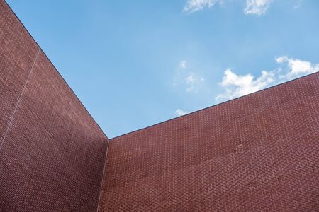 Orange brick wall against blue sky