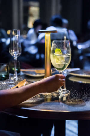 Hang holding cocktail glass on the tableの写真素材