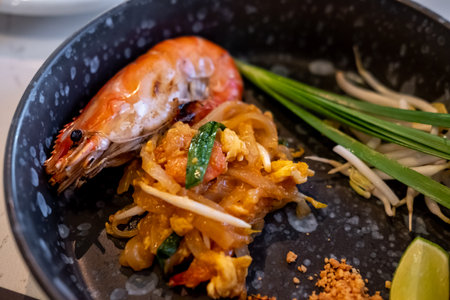 Pad Thai with shrimp serve on plate. It is a stir-fried rice noodle thai dish