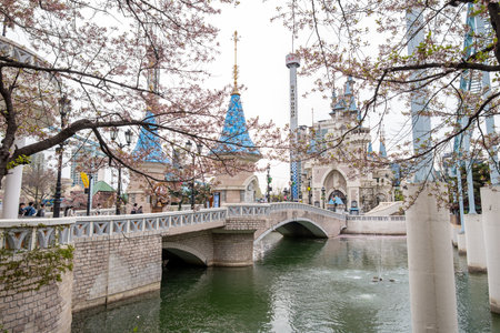 Seoul, South Korea - 4 April 2023: The castle in Magic Land, an outdoor amusement park of Lotte World with cherry blossom on the foregroundのeditorial素材