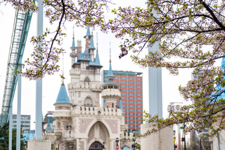 Seoul, South Korea - 4 April 2023: The castle in Magic Land, an outdoor amusement park of Lotte World with cherry blossom on the foregroundのeditorial素材