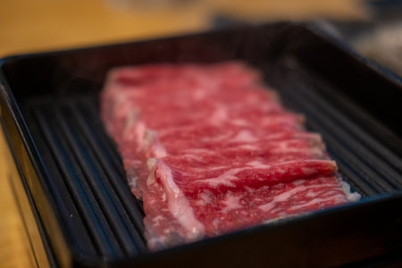 Close up of sliced raw meat, ready to be cooked by hot potの写真素材