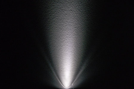 white spotlight effect on the wall, black background