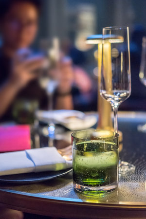Cocktail glass with plate and table lamp on the tableの写真素材