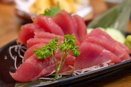 Tuna sashimi with vegetable on plate, served in a restaurantの写真素材
