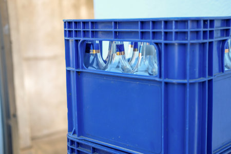 Blue plastic beer crate with empty bottlesの写真素材