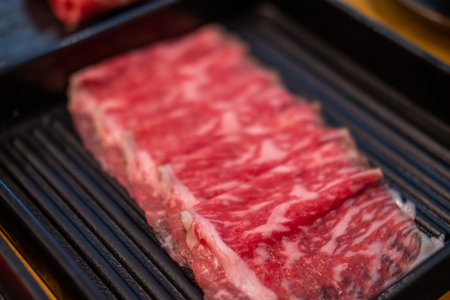 Close up of sliced raw meat, ready to be cooked by hot potの写真素材