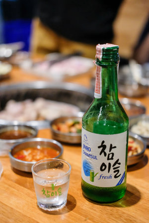 Bangkok, Thailand - 2 February 2019: Jinro Chamisul Soju with Korean food. It is a famous clear, colorless distilled beverage of Korean origin. Jinro is the largest manufacturer in South Korea.のeditorial素材