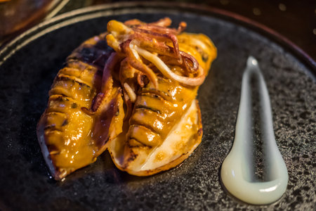 Grilled squid with sauce served on plate