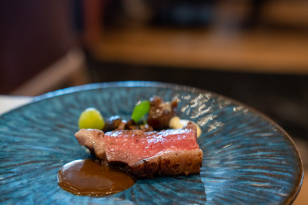 Sliced medium rare meat served on plate with sauceの写真素材